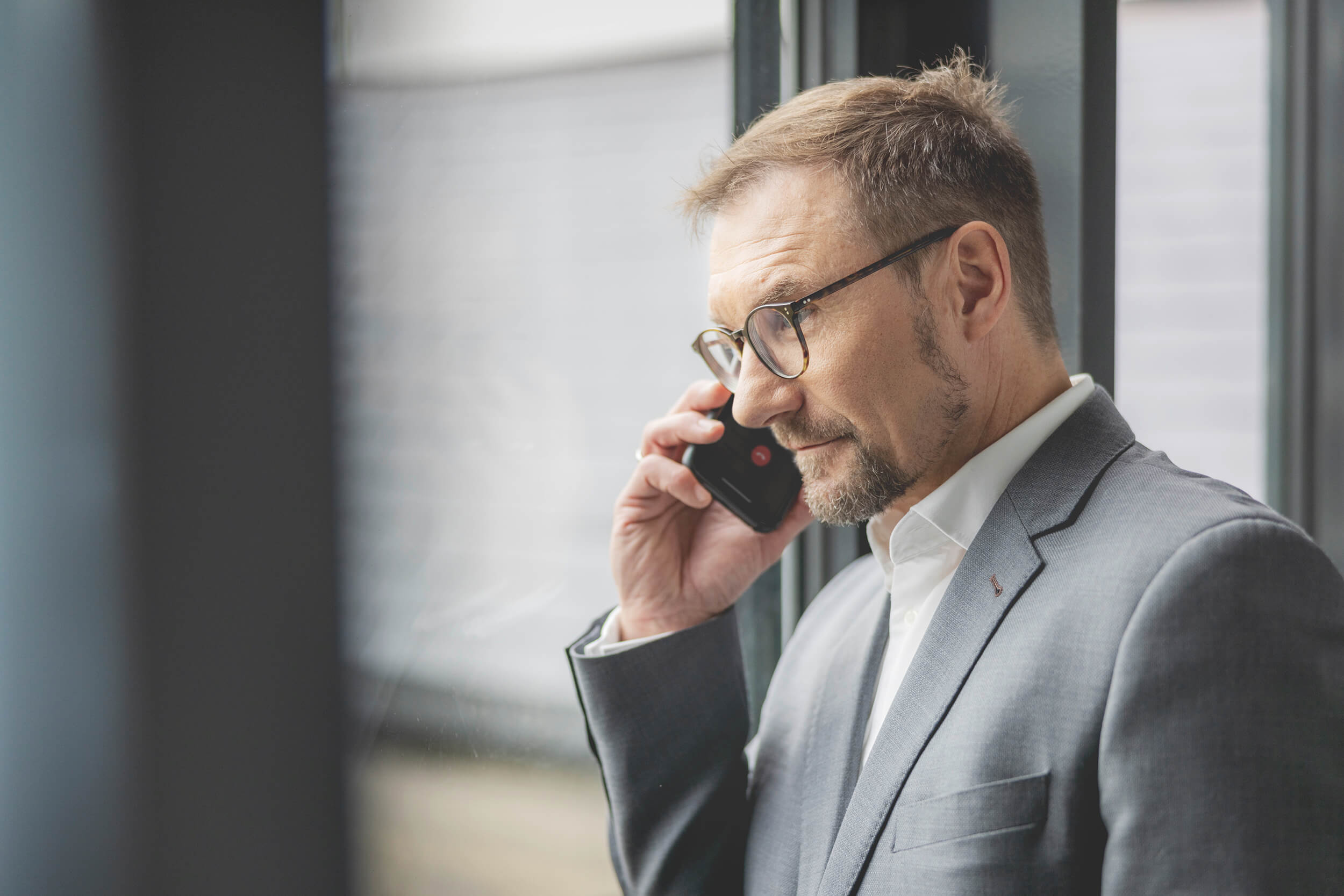HERATAX Hamburg Oliver Lindloff Partner Partner Oliver Lindloff telefoniert vor Fenster