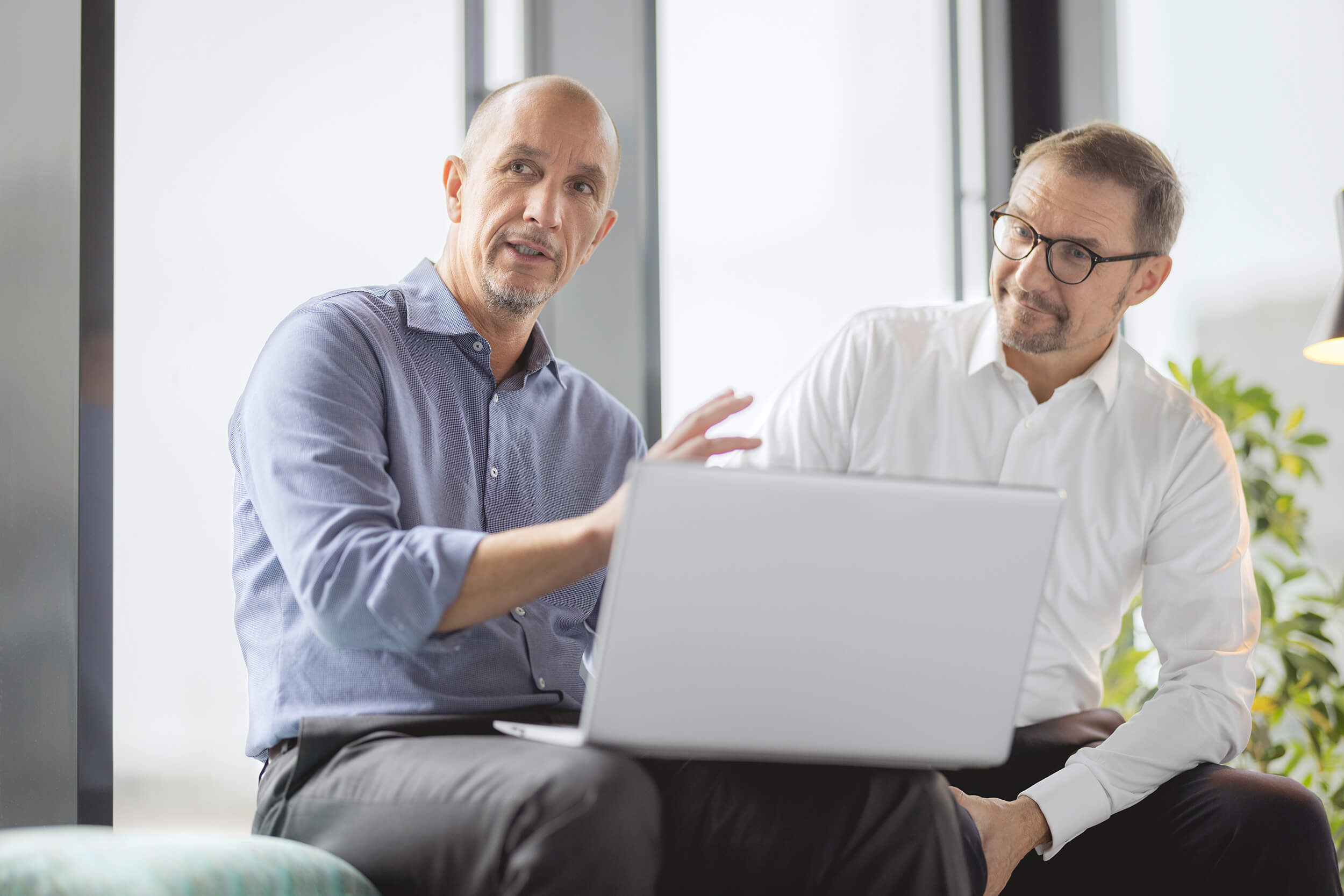 Partner Oliver Lindloff und Robert Heiss am Notebook diskutieren