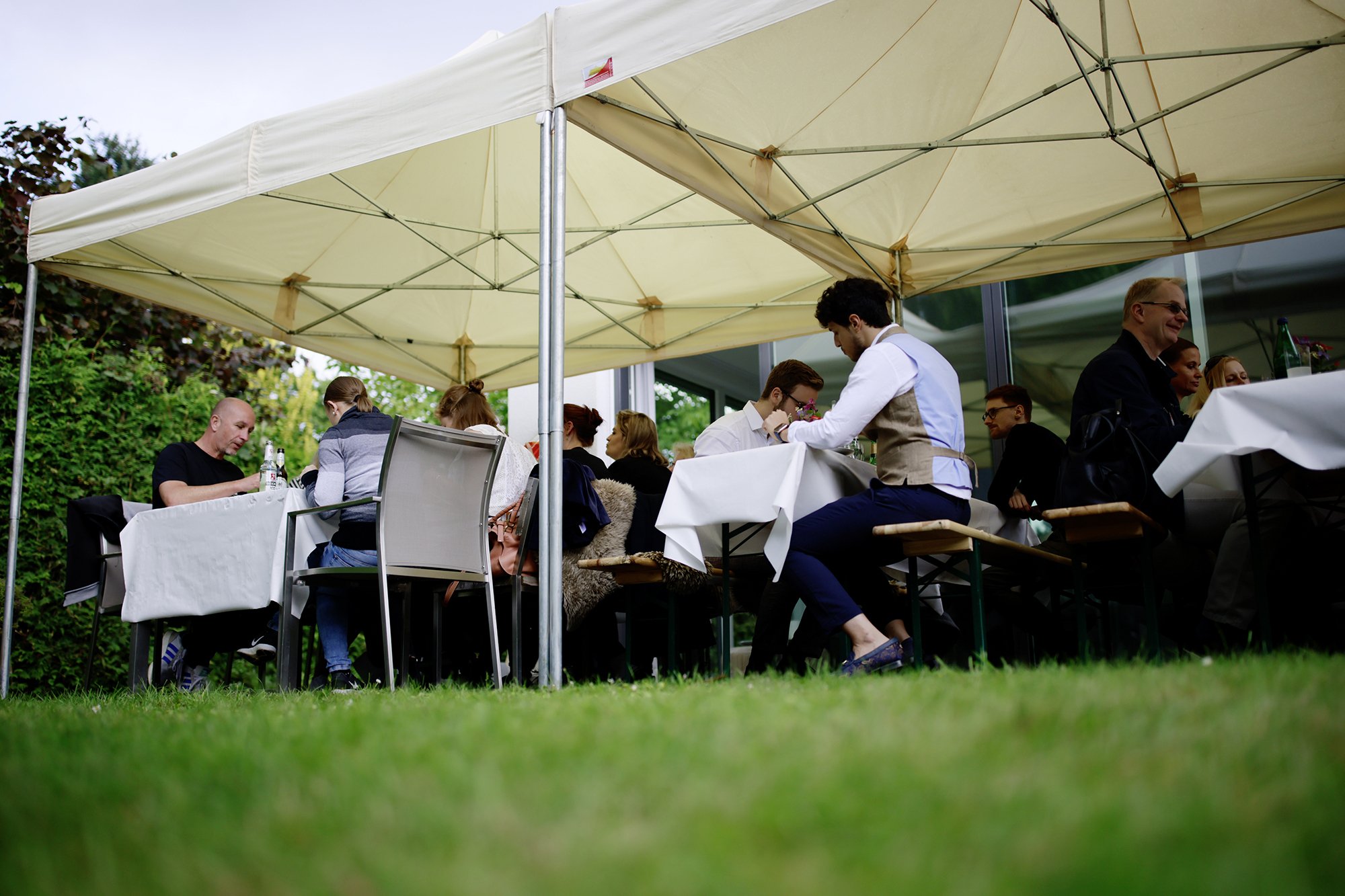 Sommerfest mit Zelt, Tischen und Stühlen Mitarbeiter beim Essen